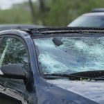 Vehicle ruined by hail including broken windows.