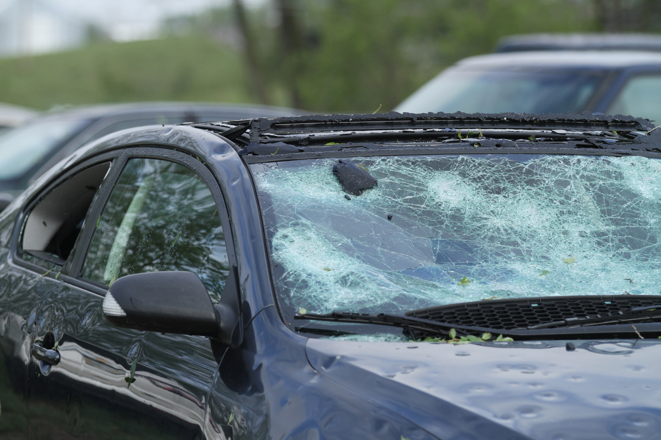 Vehicle ruined by hail including broken windows.